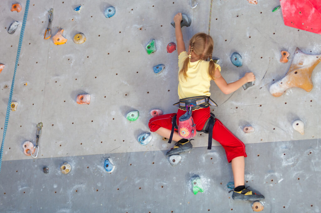 little girl climbing a rock wall